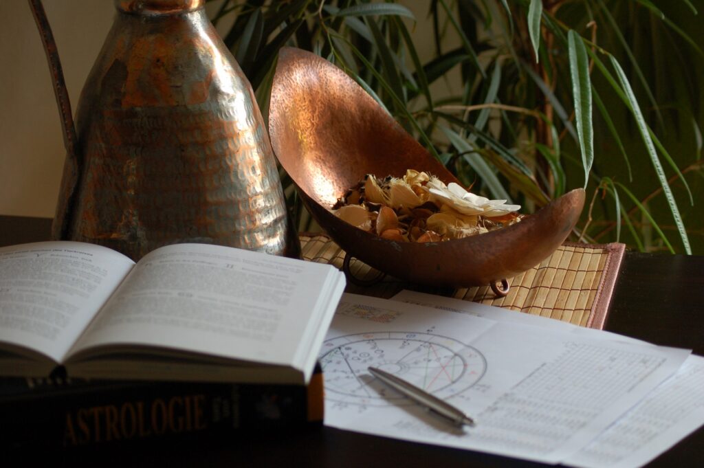 books shell pen and astrology chart